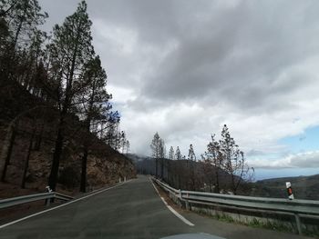 Empty road against sky in city