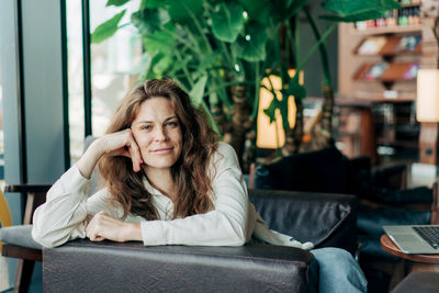 Portrait of young woman sitting at home