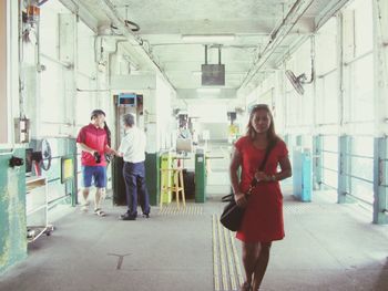 Full length of a smiling young woman standing on floor