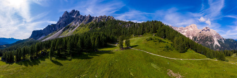 Panoramic view of green landscape and mountains against sky