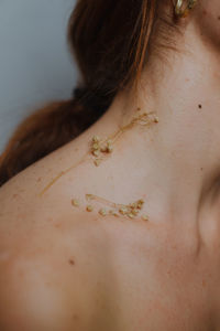 Close-up of woman with dried flowers on neck