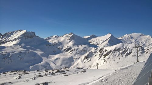 Scenic view of snowcapped mountains against clear blue sky