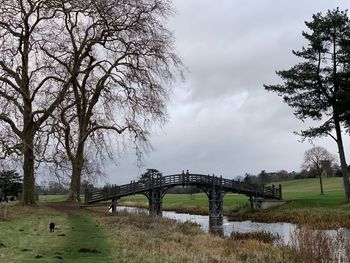 Arch bridge on field against sky