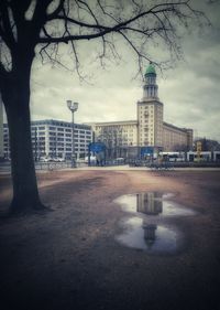 Reflection of buildings in puddle on road