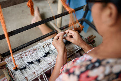 Midsection of person working on loom