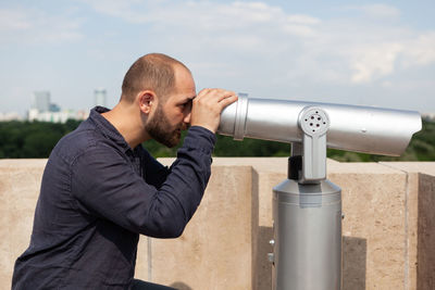 Side view of man standing against sky