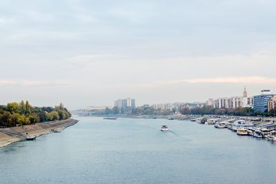 River amidst buildings in city against sky