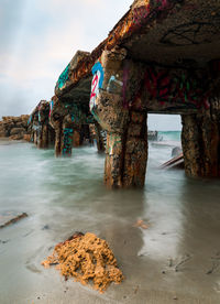 Rock formation on beach against sky