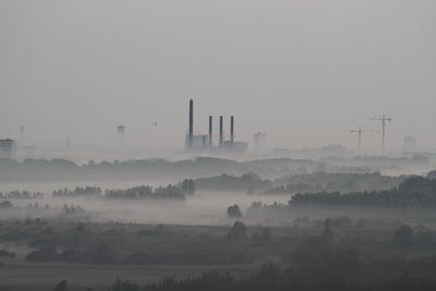 Smoke stack on landscape against sky