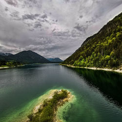 Scenic view of lake by mountains against sky