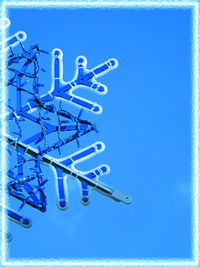 Low angle view of telephone pole against blue sky