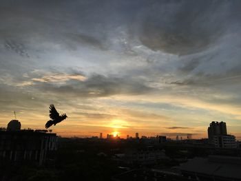 View of city against cloudy sky during sunset