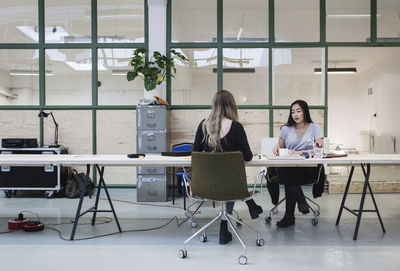 Two women working at desk in creative office