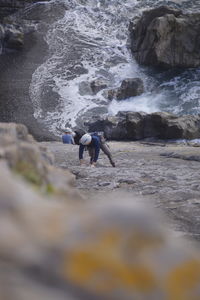 People on rocks by sea