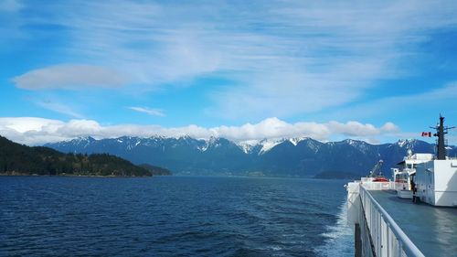 Scenic view of sea by mountains against sky