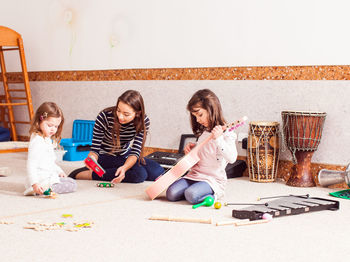 Full length of friends sitting on floor