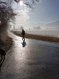 Man in water against sky during winter