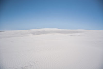 Scenic view of desert against clear blue sky