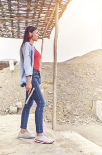 Full length of young woman standing on rock