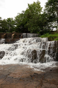 Scenic view of waterfall against sky