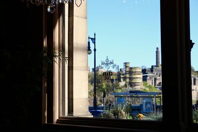 Potted plants by building against clear blue sky