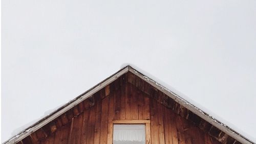 Low angle view of cottage on building against sky