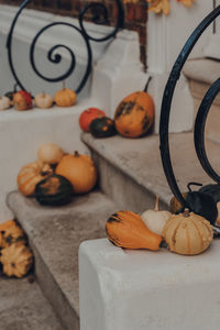Variety of different kinds of pumpkins and squashes on the doorstep of a house, halloween decor.