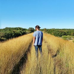 Full length of man standing in farm against clear sky