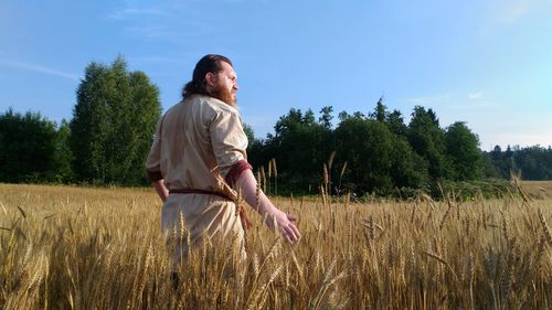 Woman standing on field against sky