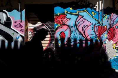 Rear view of silhouette man standing in illuminated city at night