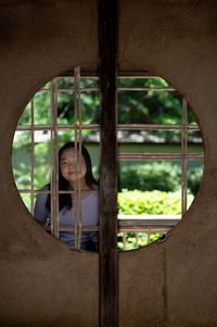 Portrait of boy looking through window
