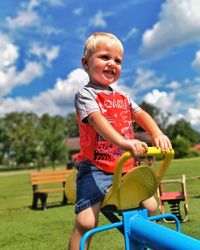 Happy boy playing in park against sky