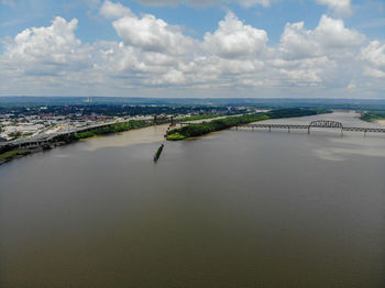 Aerial view of city by sea against sky