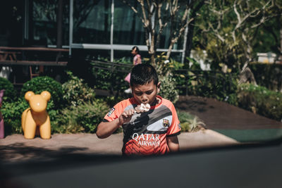 Rear view of boy looking at camera
