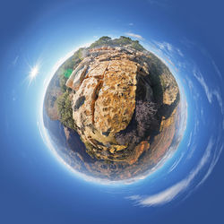 Digital composite image of rocks against blue sky