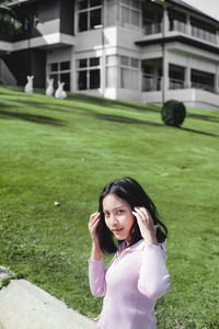 Portrait of a smiling young woman standing on grass