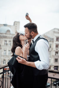 Young couple standing against city in background