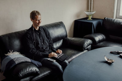 Young man sitting on sofa at home