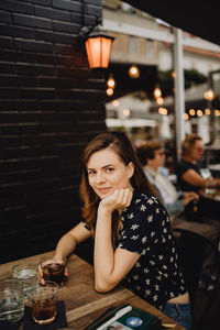 Portrait of a smiling young woman sitting at restaurant