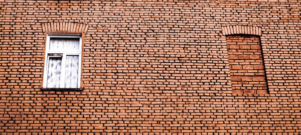Low angle view of window on brick wall of building