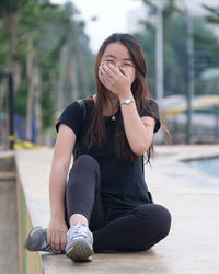 Young woman sitting on mobile phone