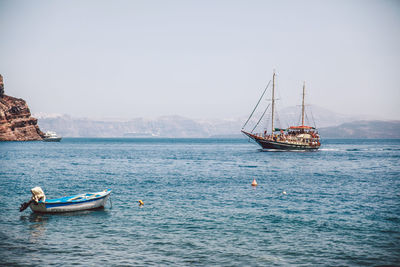 Boats moored in river against clear sky on sunny day