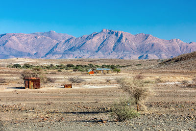 Scenic view of landscape and mountains against blue sky