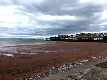 Scenic view of beach against cloudy sky