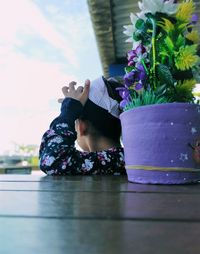 Full length of woman relaxing by potted plant on table