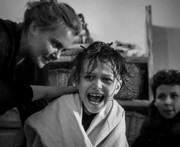 Portrait of mother cutting kid's hair 