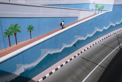 High angle view of people walking by swimming pool against building