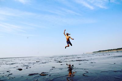 Full length of woman jumping in water