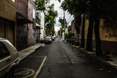 Cars parked on road amidst buildings in city