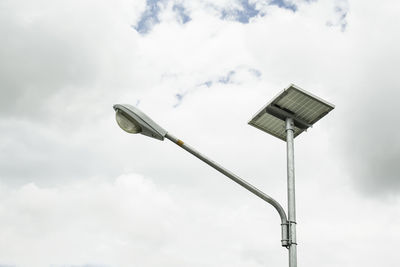 Low angle view of solar powered street light against cloudy sky